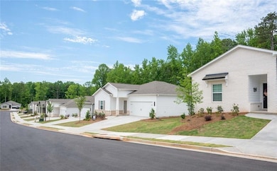 View of front of house featuring brick siding, concrete driveway, an attached garage, and a front lawn