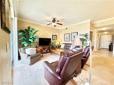 Living area featuring a ceiling fan, light carpet,