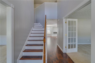 Stairway with a textured ceiling, wood finished fl