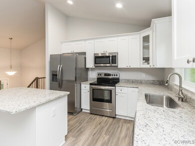 Kitchen featuring white cabinetry, light hardwood