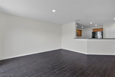 Unfurnished living room featuring dark wood-type flooring