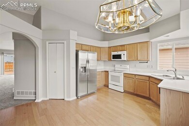 Kitchen with a notable chandelier, white appliance