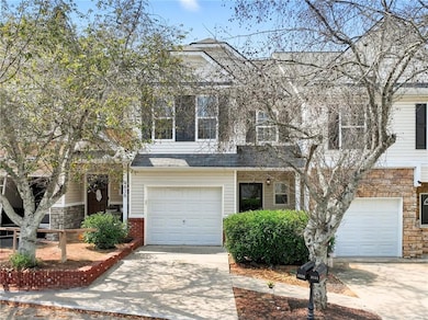 View of front facade featuring stone siding, driveway, and an attached garage