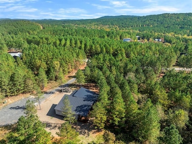 Aerial view of property and surrounding area featuring a forest