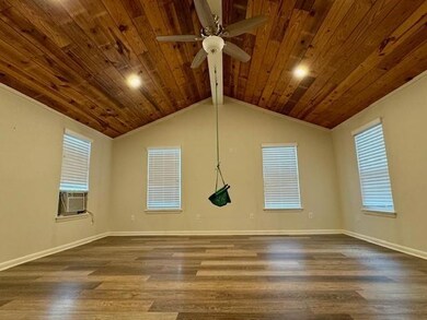 Empty room with vaulted ceiling with beams, dark h