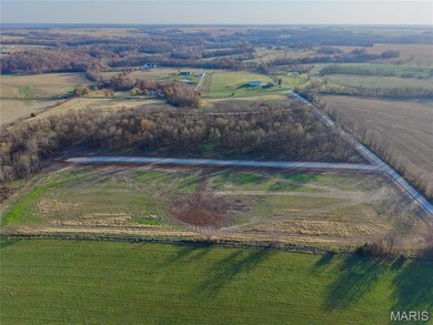 Aerial view of property's location featuring rural landscape and farmland