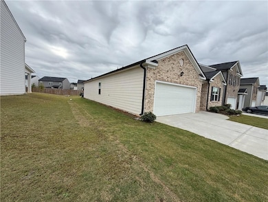View of property exterior with brick siding, driveway, and an attached garage