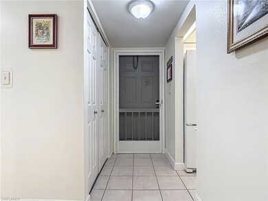 Hall featuring light tile patterned flooring and baseboards