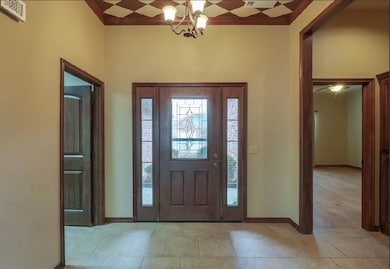 Foyer featuring a healthy amount of sunlight, a chandelier, and ornamental molding