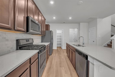 Kitchen featuring stainless steel appliances, tas