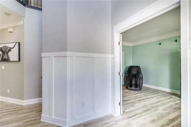 Foyer entrance featuring plenty of natural light, wood finished floors, a towering ceiling, and stairs
