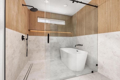 Full bath featuring a tile shower and a freestand