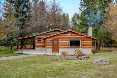 View of front of home with a front lawn, an attached carport, and a chimney