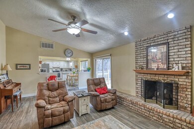 Living room with a fireplace, lofted ceiling, ligh