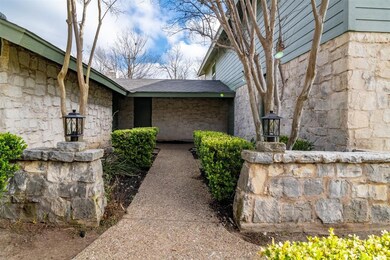Doorway to property with stone siding and roof wi