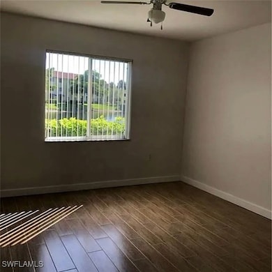 Spare room featuring ceiling fan and dark wood-style floors