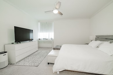 Bedroom featuring ceiling fan, carpet flooring, and ornamental molding