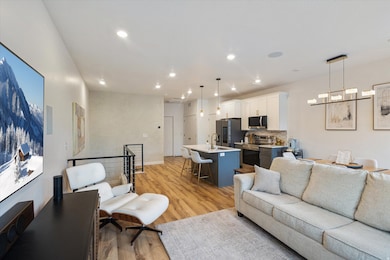Living area with light wood finished floors and recessed lighting