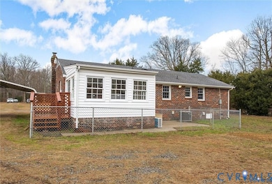Back of property with a chimney, a deck, and a gate