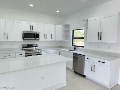 Kitchen featuring white cabinetry, stainless steel