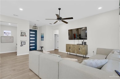 Living area with recessed lighting, light wood-type flooring, and ceiling fan