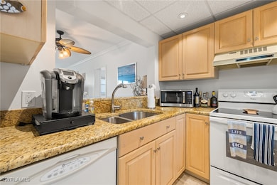 Kitchen with light stone counters, light brown cab