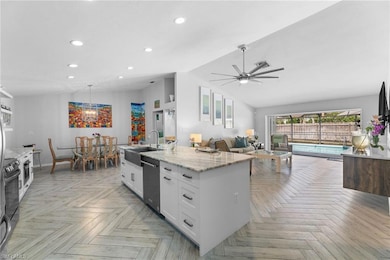 Kitchen with sink, light stone counters, vaulted c