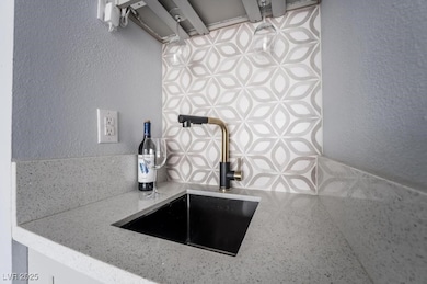 Kitchen view of a sink, a textured wall, and light