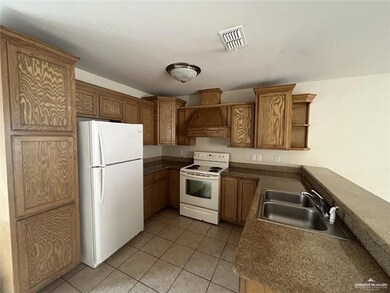 Kitchen with white appliances, open shelves, light tile patterned floors, and premium range hood