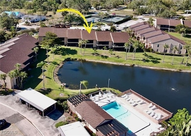 Aerial view of residential area featuring a nearby body of water and a pool