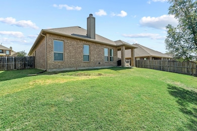 Large grassy rear yard with covered patio