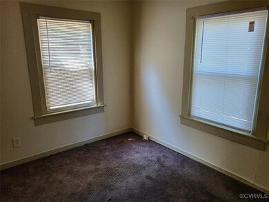 Spare room featuring dark carpet