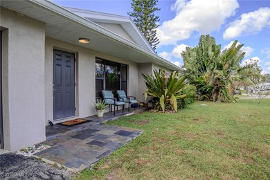 Entrance to property featuring a patio and a yard