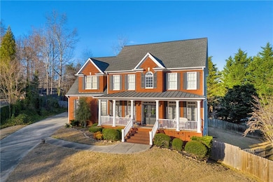 View of front of property featuring a porch, a standing seam roof, a metal roof, roof with shingles, and concrete driveway