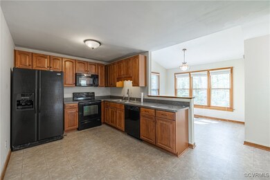 Kitchen with a sink, brown cabinets, black applian