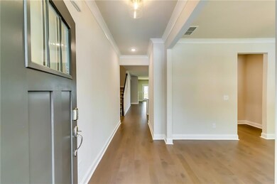 Entrance foyer featuring wood finished floors, crown molding, baseboards, and recessed lighting