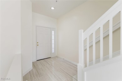 Foyer with light wood-style floors and baseboards