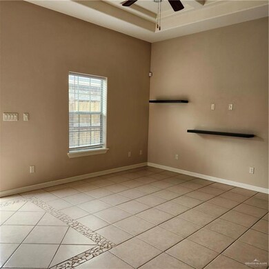 Unfurnished room featuring ceiling fan, light tile patterned flooring, and baseboards