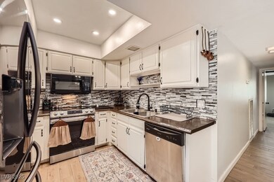 Kitchen featuring black appliances, a sink, dark c