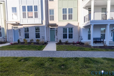 View of front facade featuring brick siding, a front lawn, and a balcony