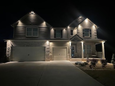 Craftsman house with an attached garage, covered porch, concrete driveway, and brick siding