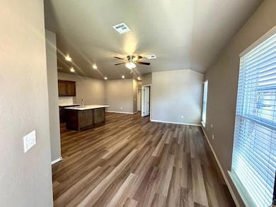 Unfurnished living room featuring a ceiling fan, dark wood finished floors, baseboards, recessed lighting, and a sink