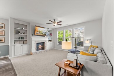 Living area with baseboards, ceiling fan, a firepl