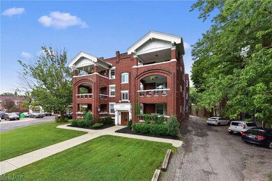 View of front facade with a front yard, uncovered parking, and brick siding
