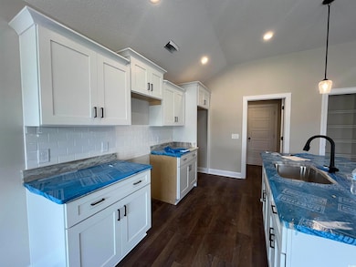 Kitchen featuring lofted ceiling, dark wood-type f