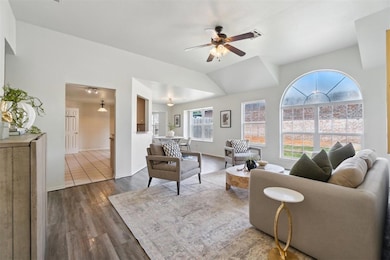 Living area featuring healthy amount of natural light, a ceiling fan, and woodflooring