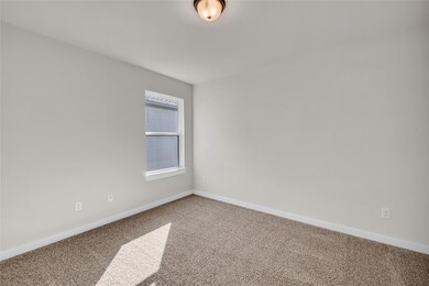 Carpeted empty room featuring baseboards