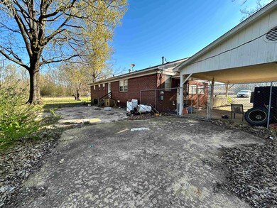 View of side of property with a gate, fence, and b
