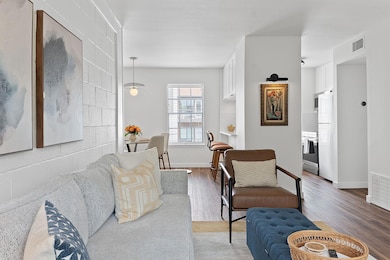 Living area with visible vents, baseboards, and w