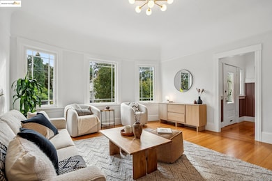 Living room with light wood-style floors, plenty of natural light, and a chandelier